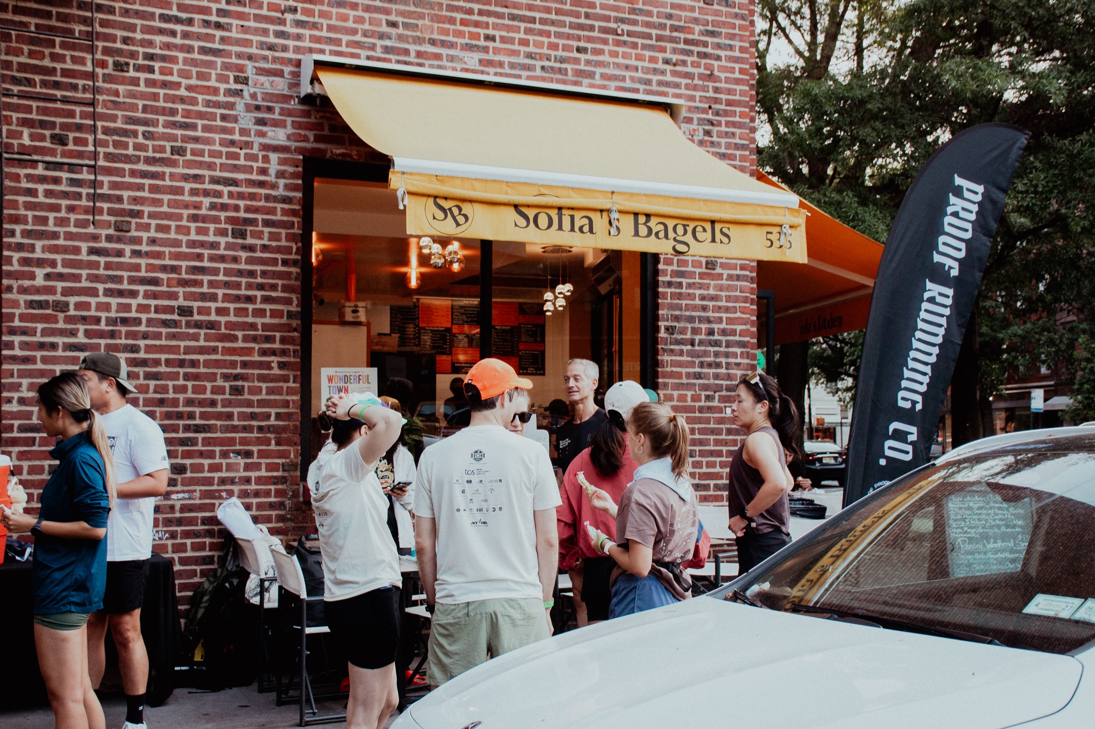 Proof runners gathering outside a neighborhood bagel shop